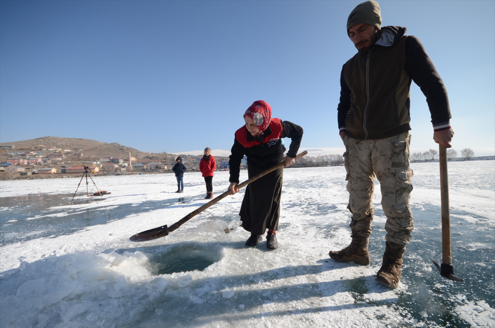 Eskimo usulü balık avlayan kadın, ekmeğini buzun altından çıkartıyor